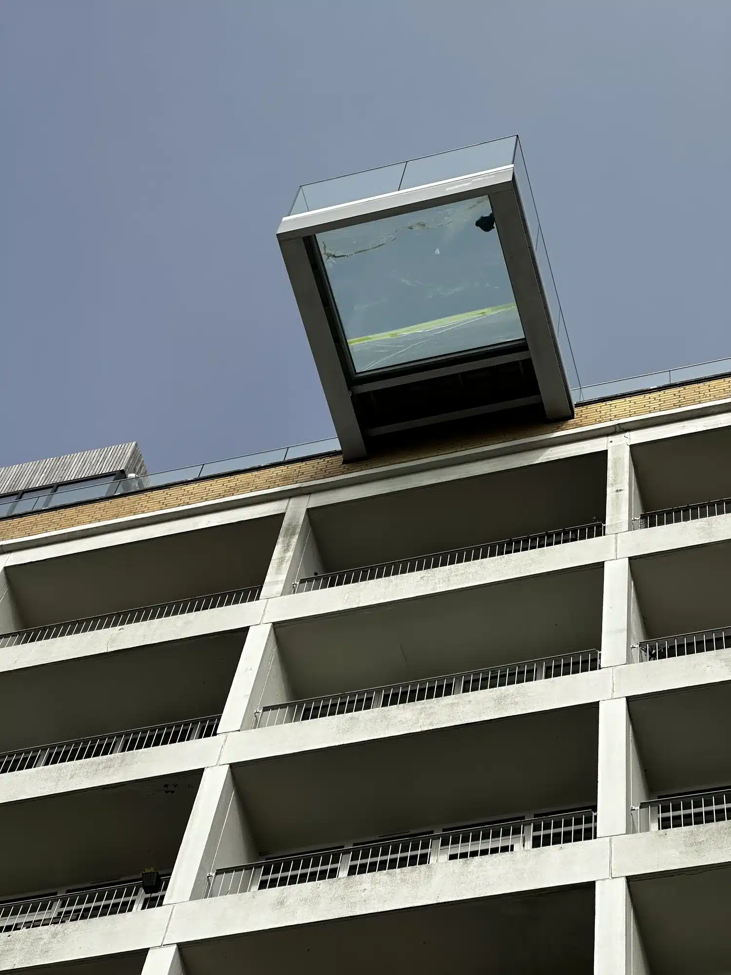 Rude i gulvet på tagterrassen set nedefra – den fremspringende glasboks på toppen af bygningen i Aalborg