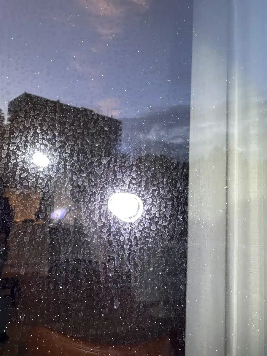 Nærbillede af kalk og aflejringer fra betonfacaden på glasset