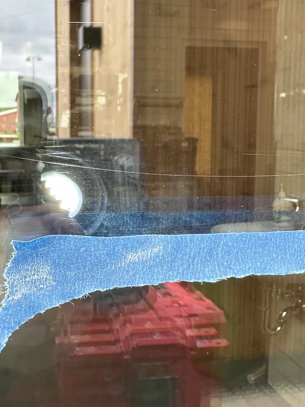 Ridser i vinduesglasset før polering, med malertape langs kanten