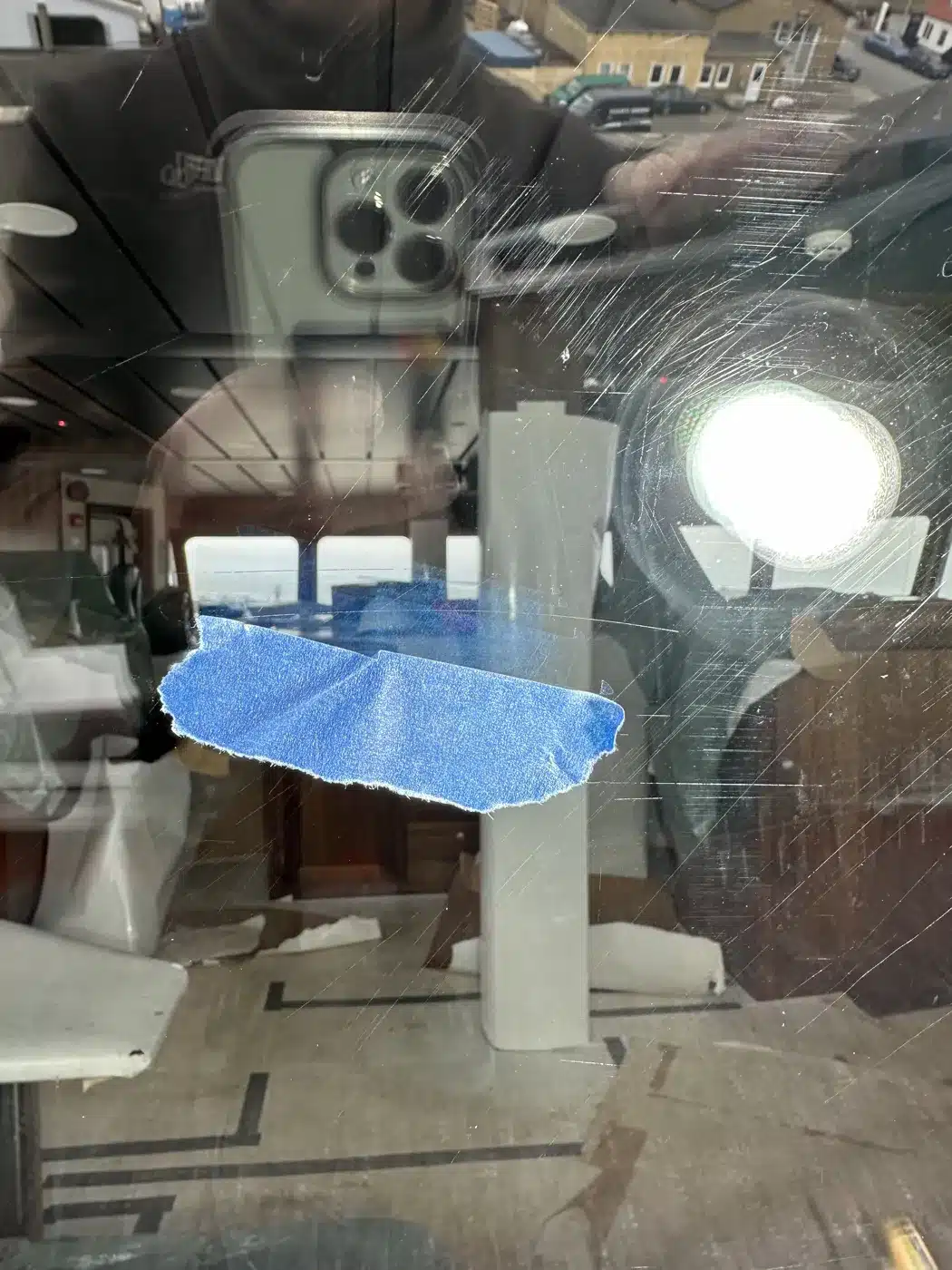 Window on Myggenes with scratches marked with blue tape, before polishing