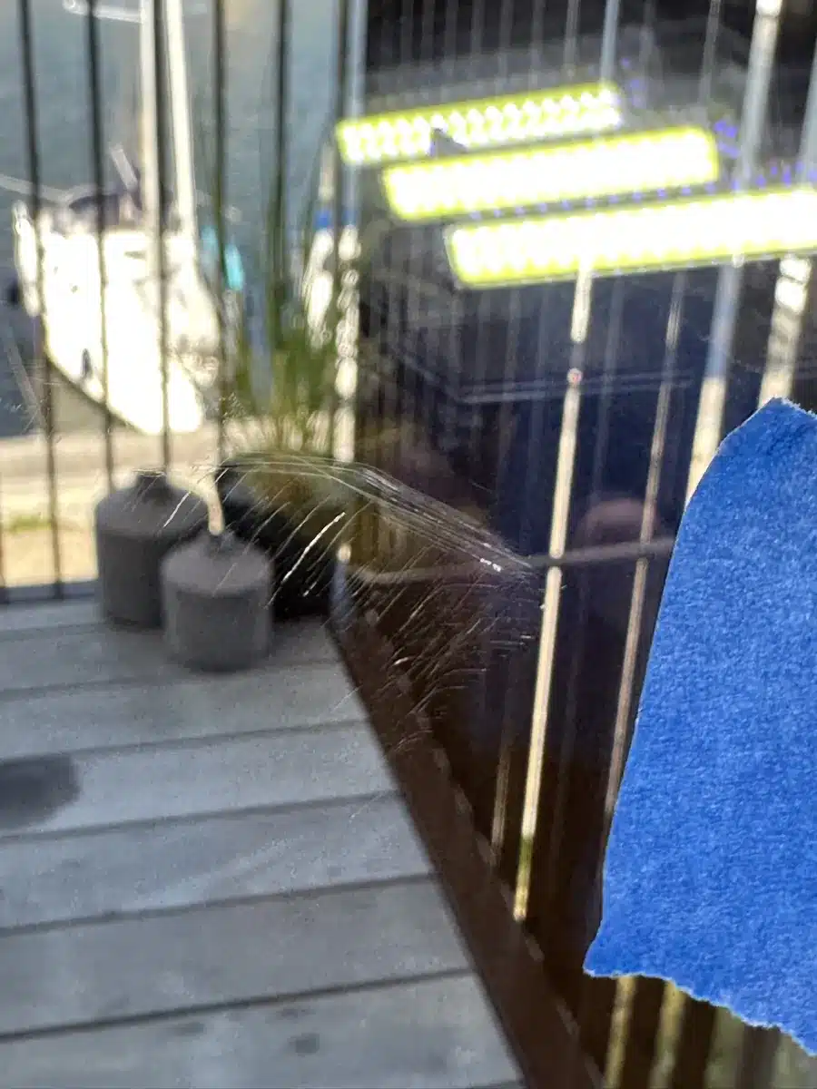 Ridser i terrassedørens glas før polering, markeret med tape